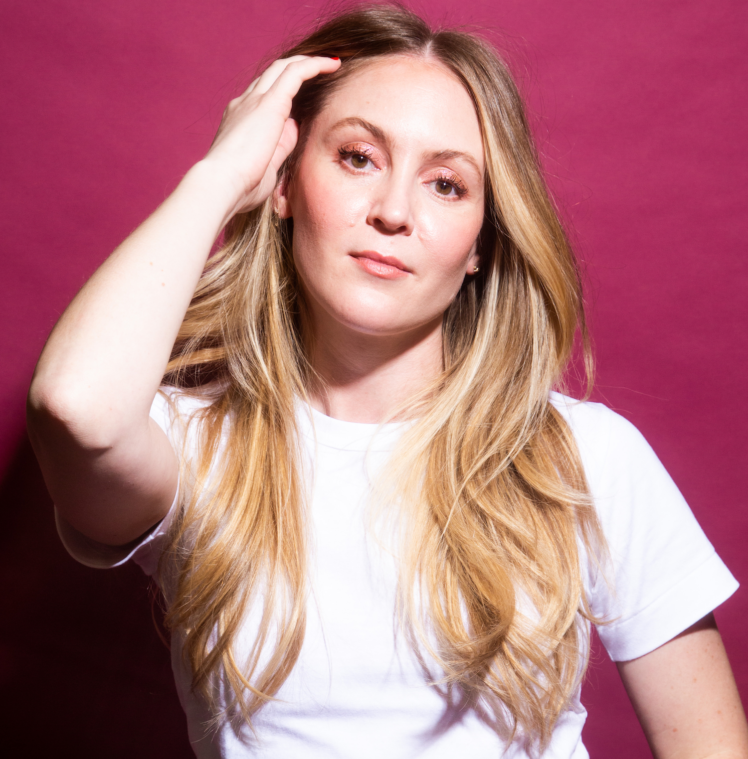 a white woman with long blonde hair in a white t-shirt