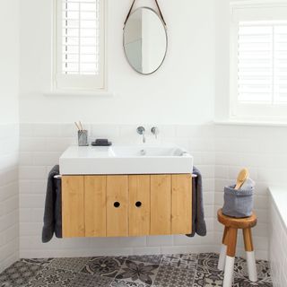 bathroom with white walls and printed tiled flooring