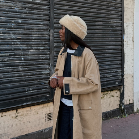 Liv in a fuzzy winter hat and trench coat