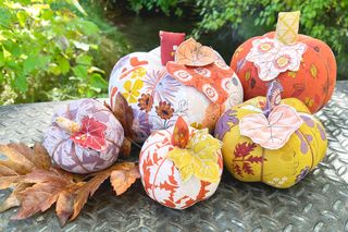 fabric pumpkins in various sizes and designs with real leaves
