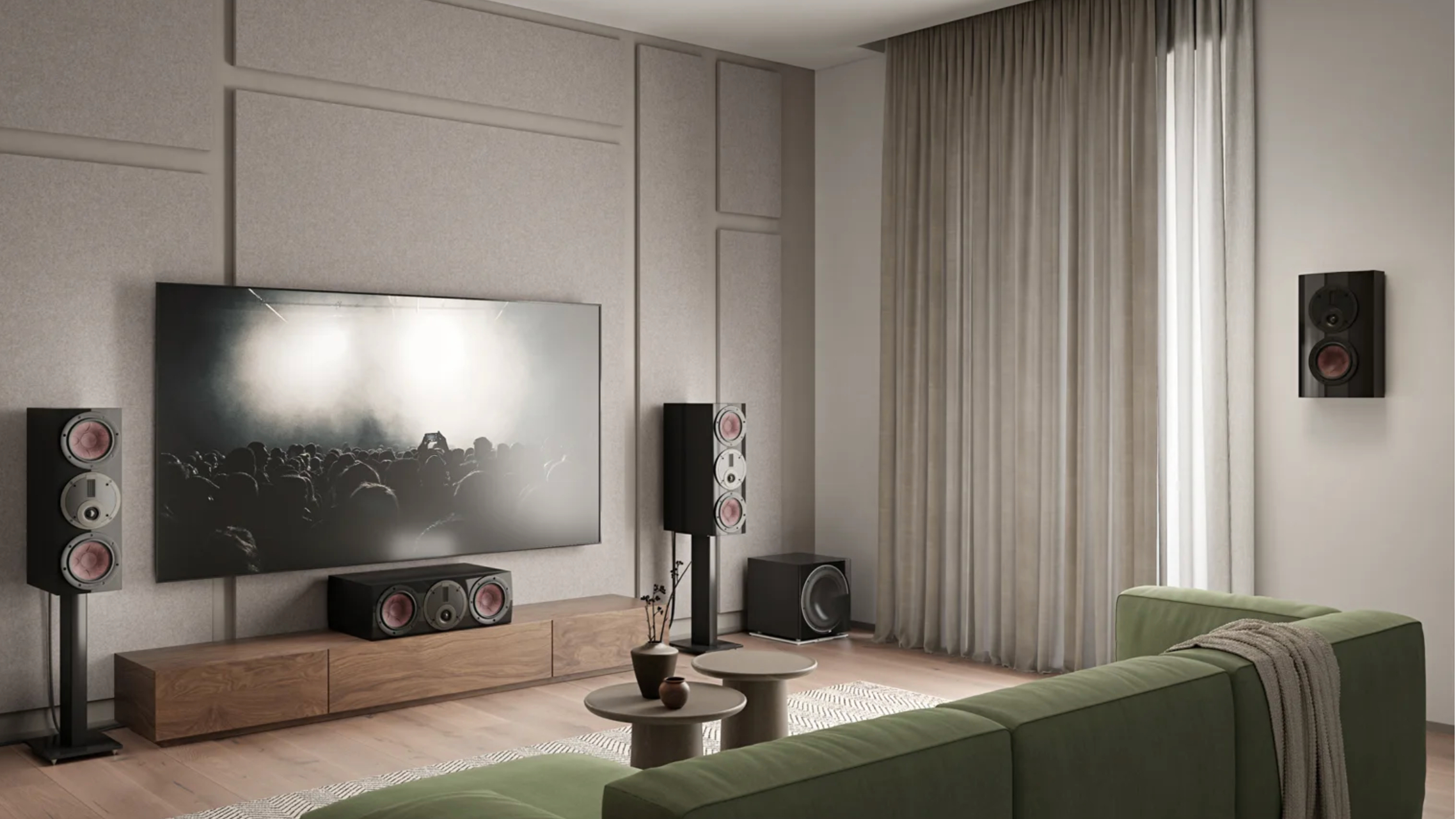 Three Rubikore Cinema speakers and a Rubikore On-Wall speaker, around a TV in a beige sitting room