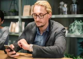 Man using his smartphone and checking his watch