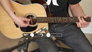 Man recording his acoustic guitar using two microphones