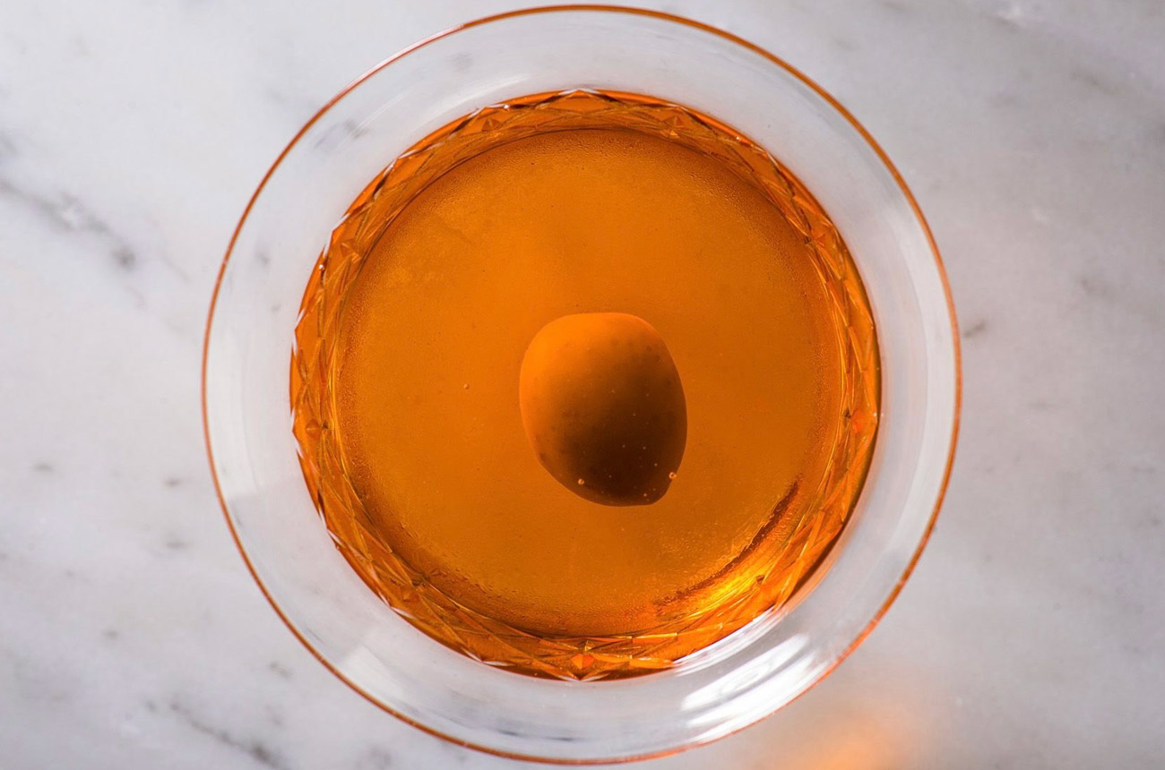 A top view looking down into a cocktail glass with an orange drink