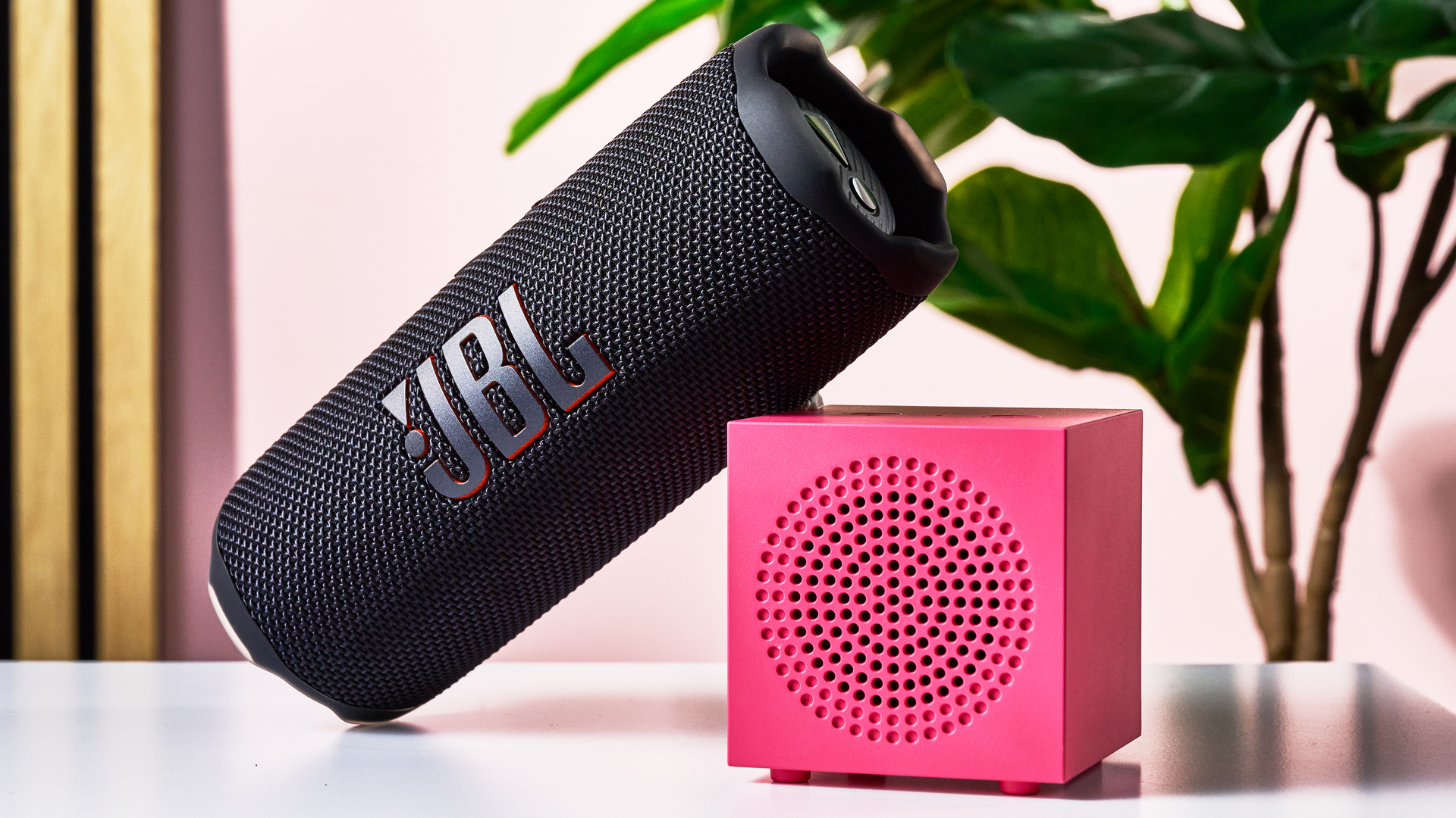 The JBL Flip 7 resting at an angle on a single pink IKEA Kallsup speakers.
