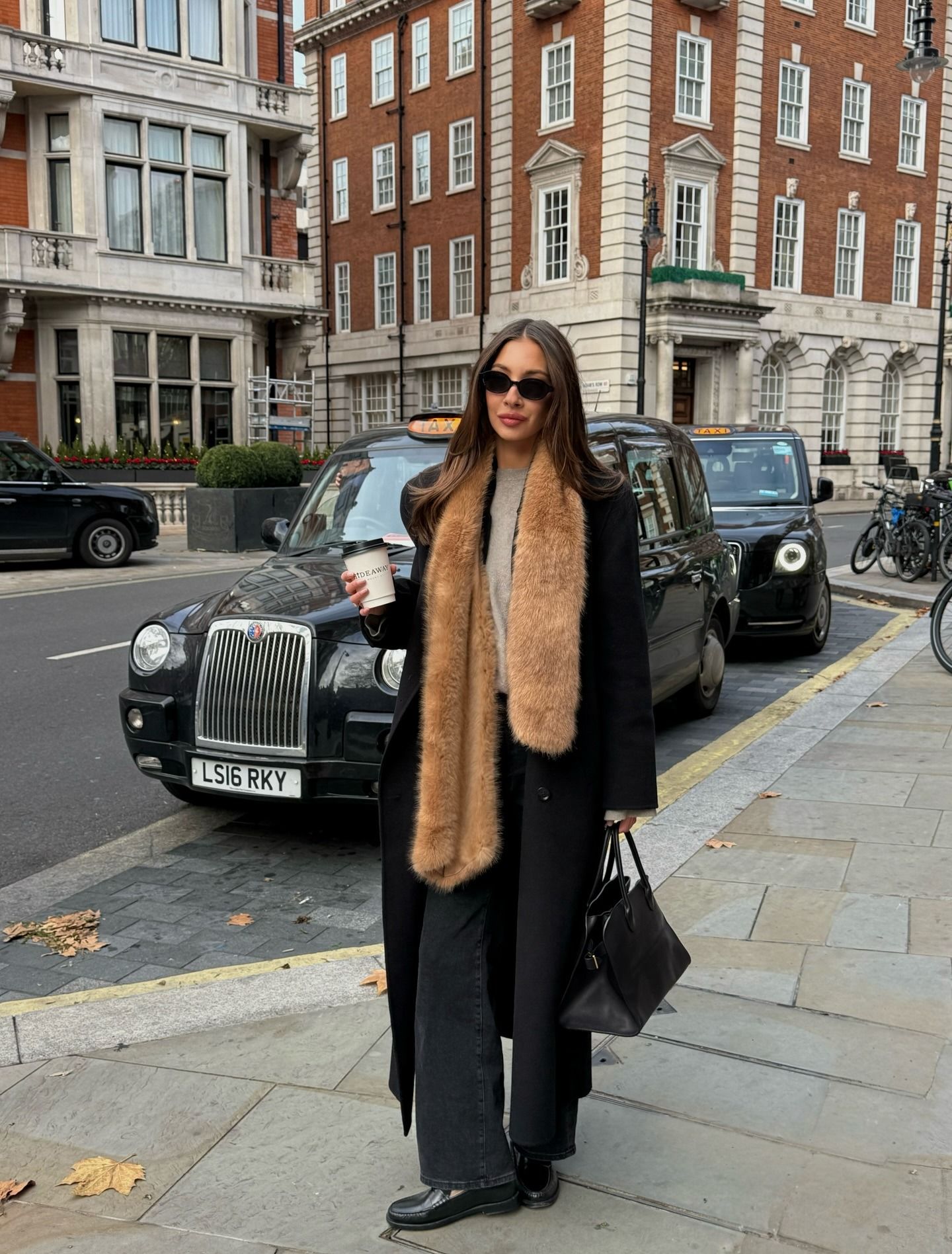 Influencer wearing a fur scarf and jeans with loafers