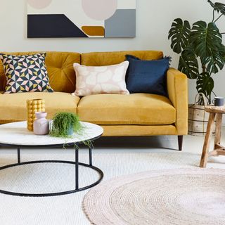 room with yellow sofa potted plant and cushions