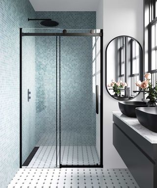Black shower enclosure and black basins in small bathroom