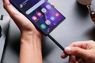 A Samsung Galaxy Note 20 Ultra 5G user inserting the stylus into the smartphone