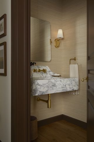powder room with brass taps and marble basin