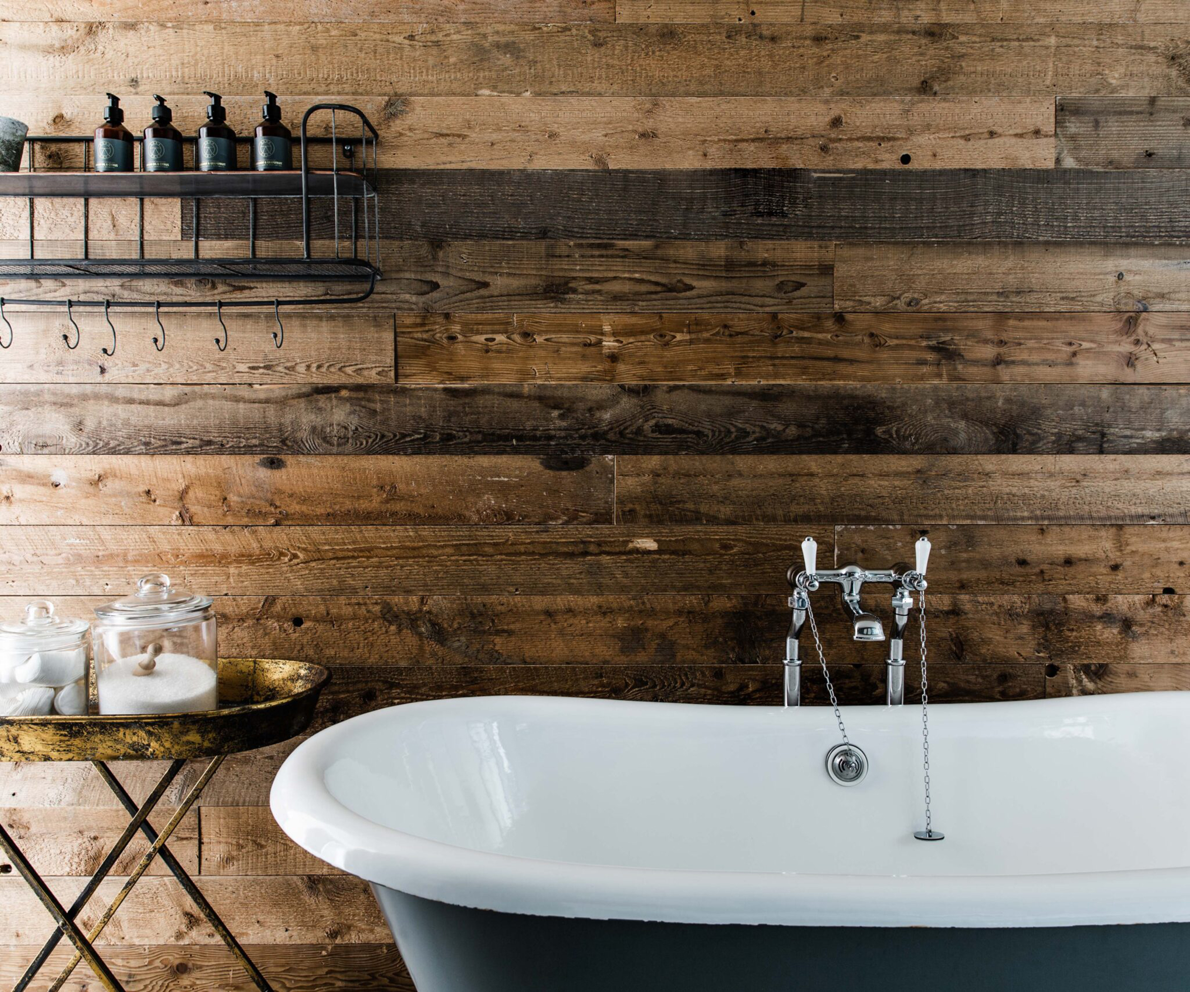 bathroom with rolltop bath and timber wall cladding