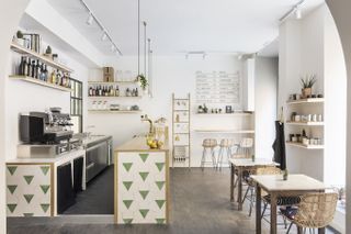 An industrial chic cafe in Rome features wooden and tile decor and a white-washed aesthetic.