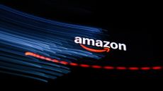 Amazon logo and branding pictured hovering above a laptop keyboard with keys blurred.