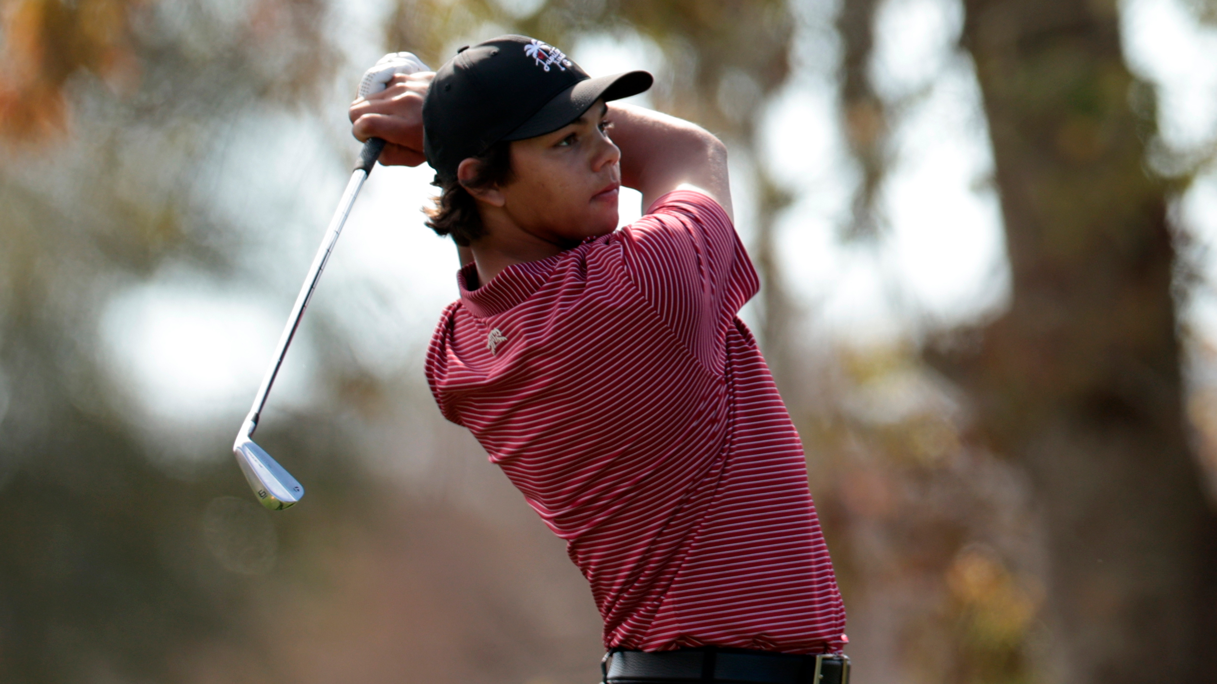 Charlie Woods plays an iron shot