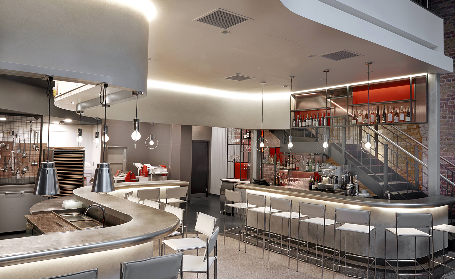 Bala Baya restaurant with gently curving zinc counter wrapped around the open kitchen with white leather and chrome bar stools