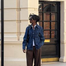 liv wears denim fitted jacket, brown slacks, and suede heels