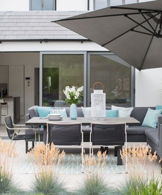 outdoor sitting with grey sofa and umbrella