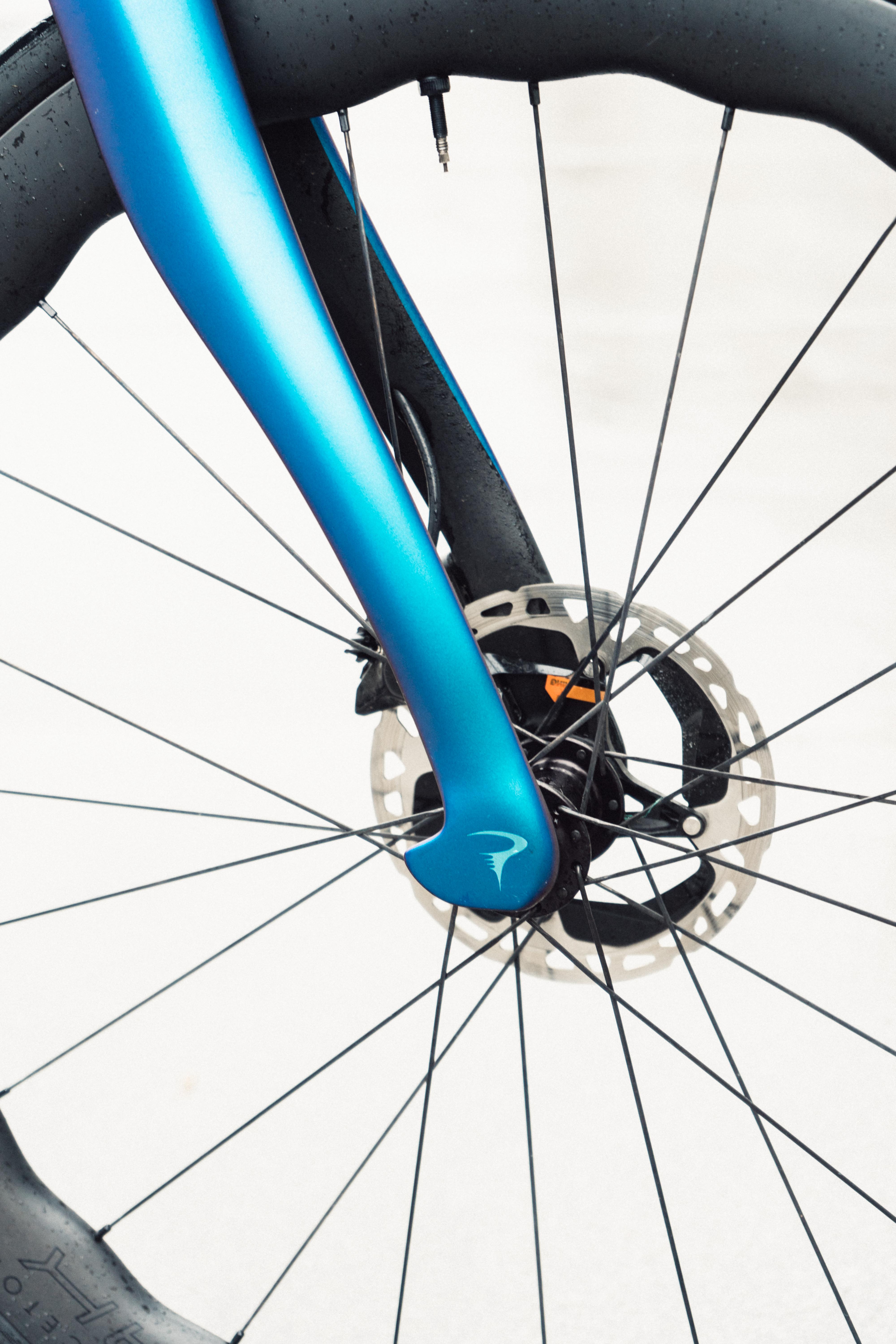 A close up of the fork of a blue bike