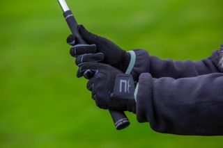 Cobra golf winter gloves gripping a golf club