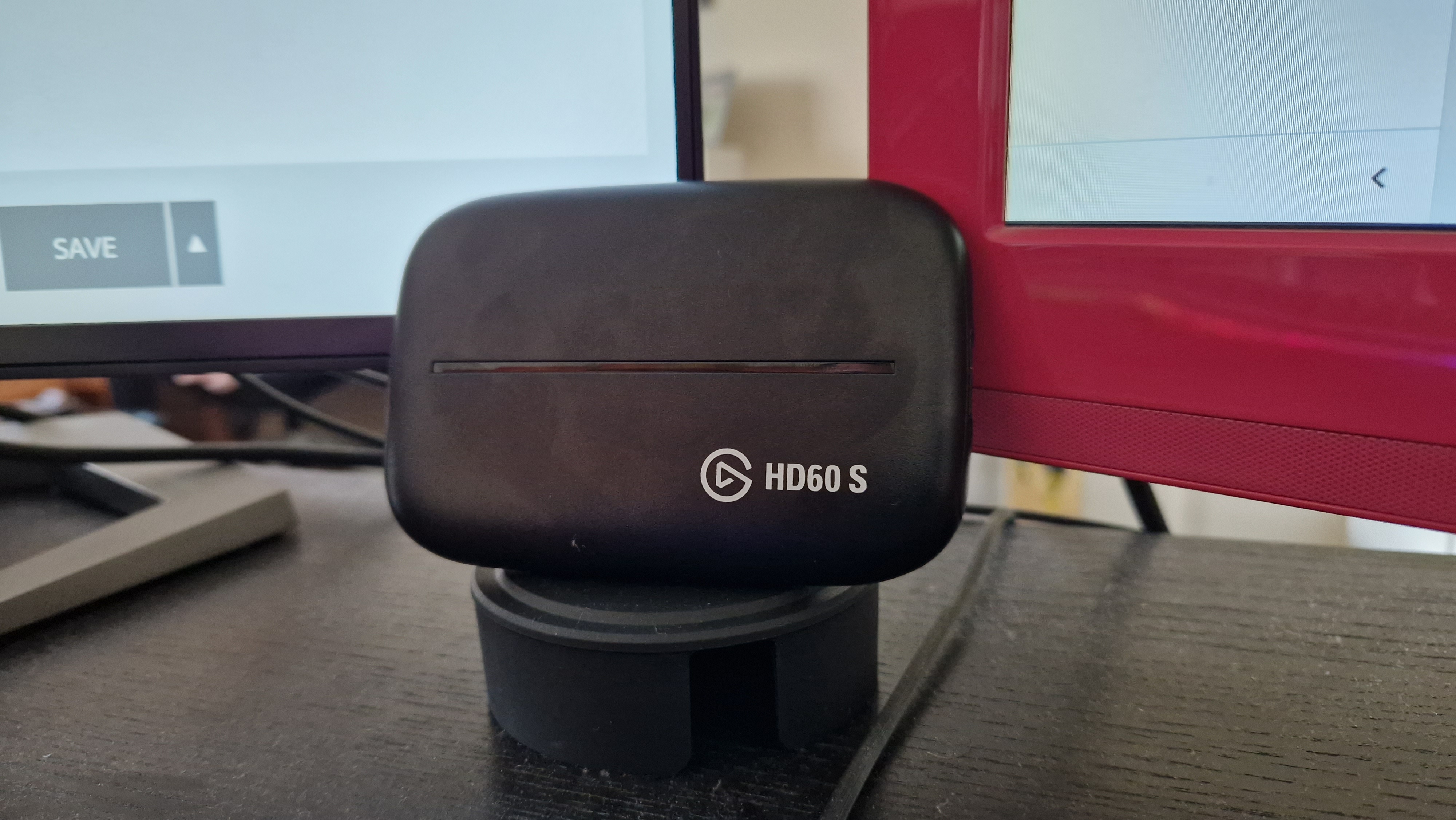 Elgato HD60S propped up against two monitors