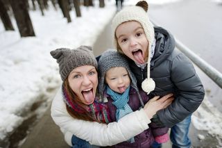 happy mom with her kids in the snow