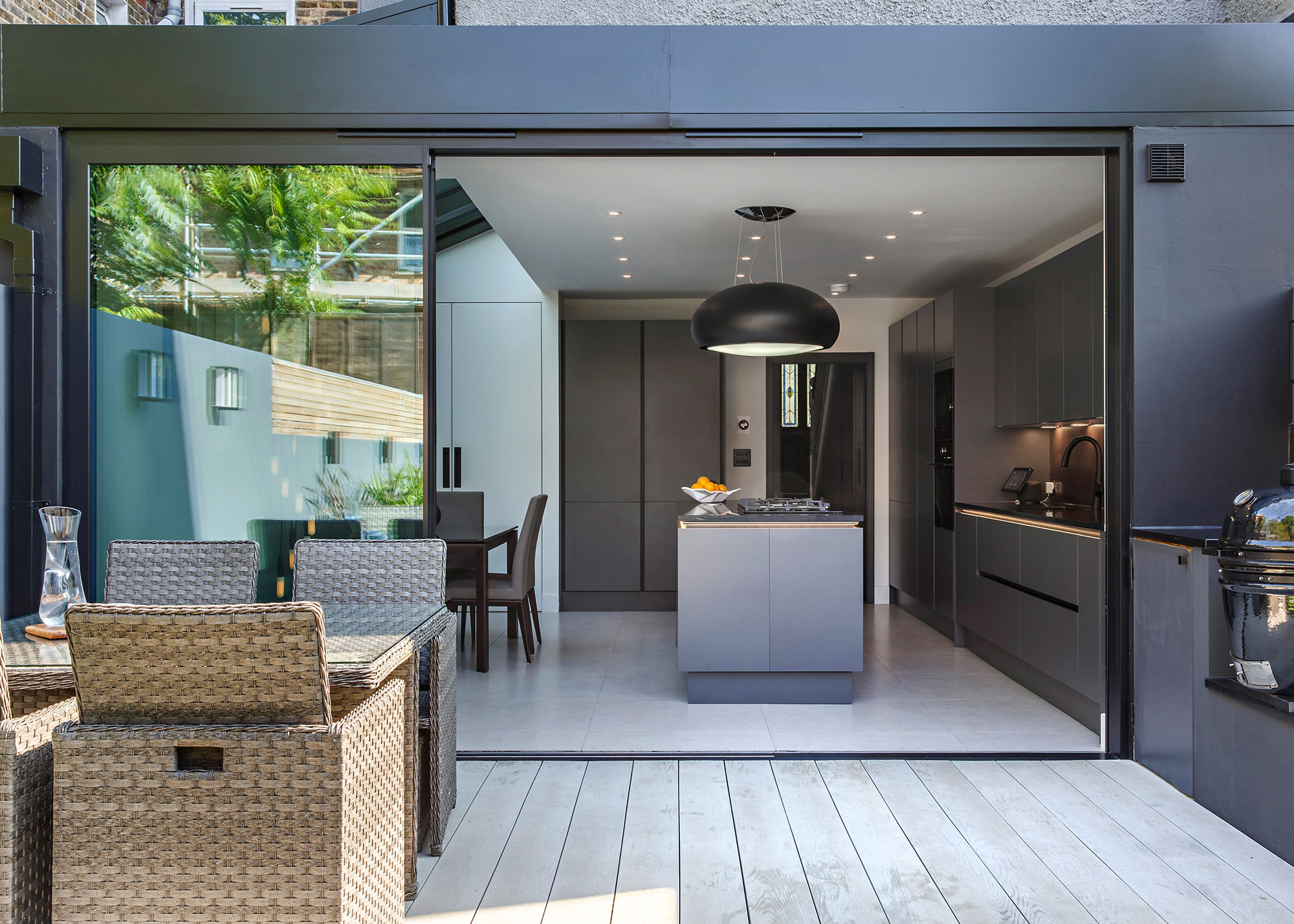 kitchen extension with sliding doors and pale grey decking on patio