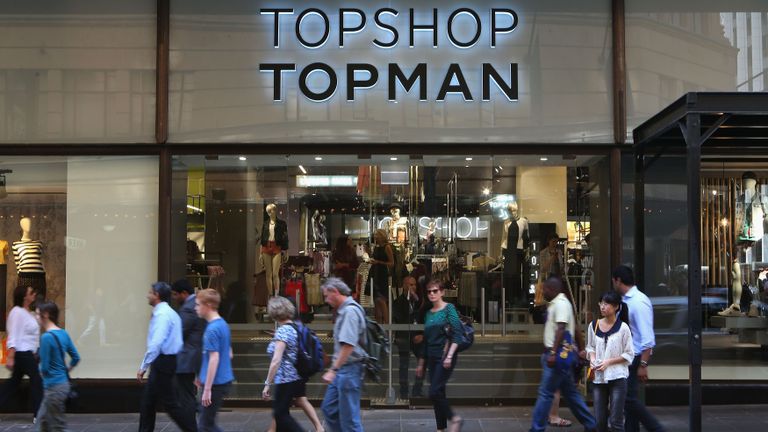 Shoppers walking past Topshop store
