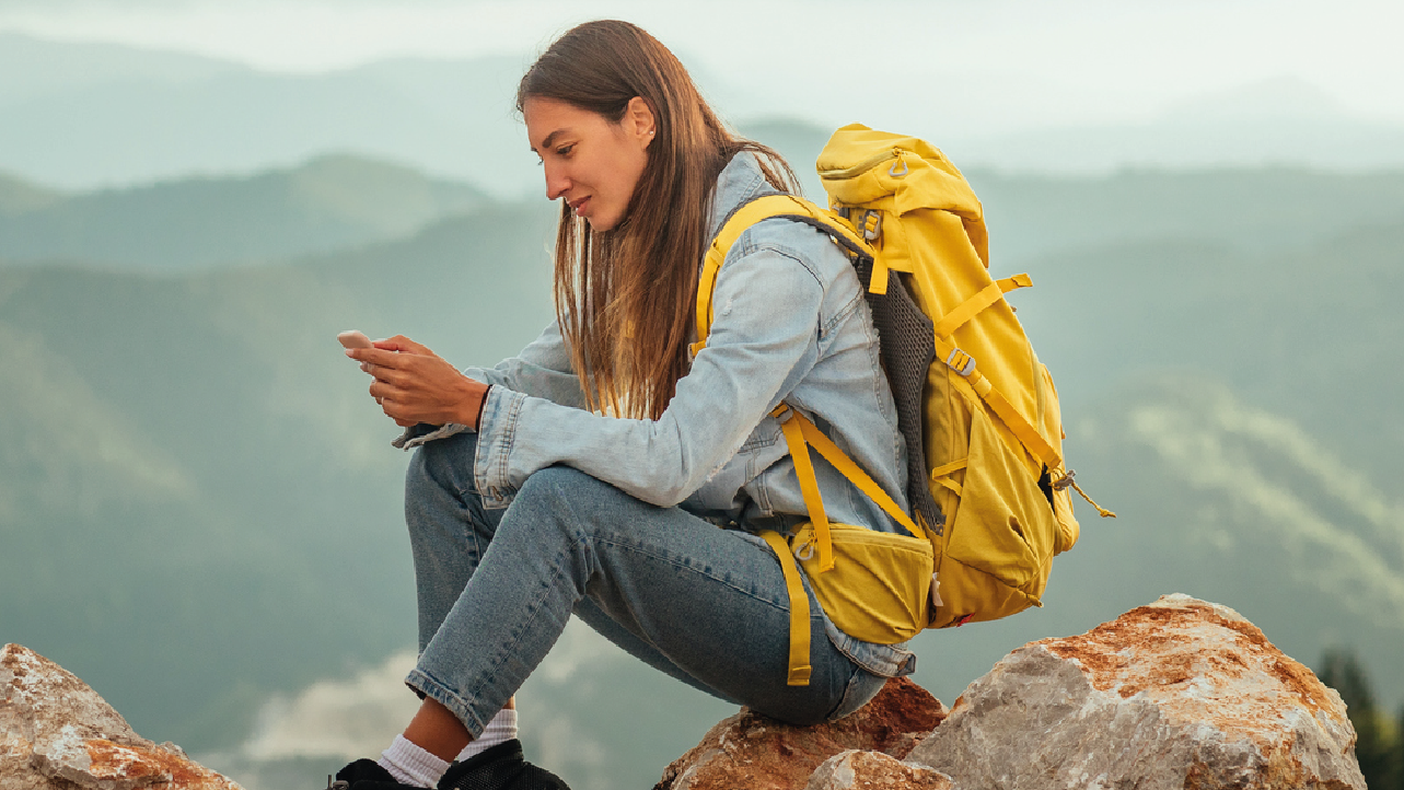 A person on their phone on a mountain.