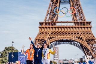 Paris, France - Women’s Road Race - Kristen Faulkner (USA) on the podium receiving the Olympic Gold Medal after winning the Women's Road to become Olympic Champion in front of the Eiffel Tower with Marianne Vos (Netherlands) receives the Olympic Silver Medal and Lotte Kopecky (Belgium) receives the Olympic Bronze Medal