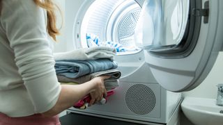 Woman doing laundry with clothes dryer