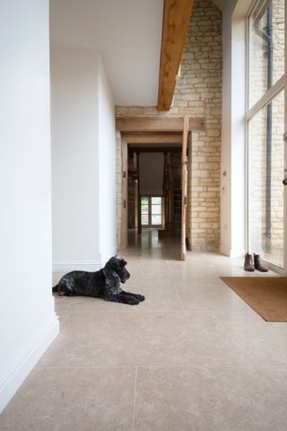 neutral hallway with stone flooring, exposed brick, white walls