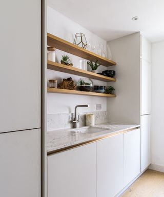 white utility cupboards with free floating wooden shelves