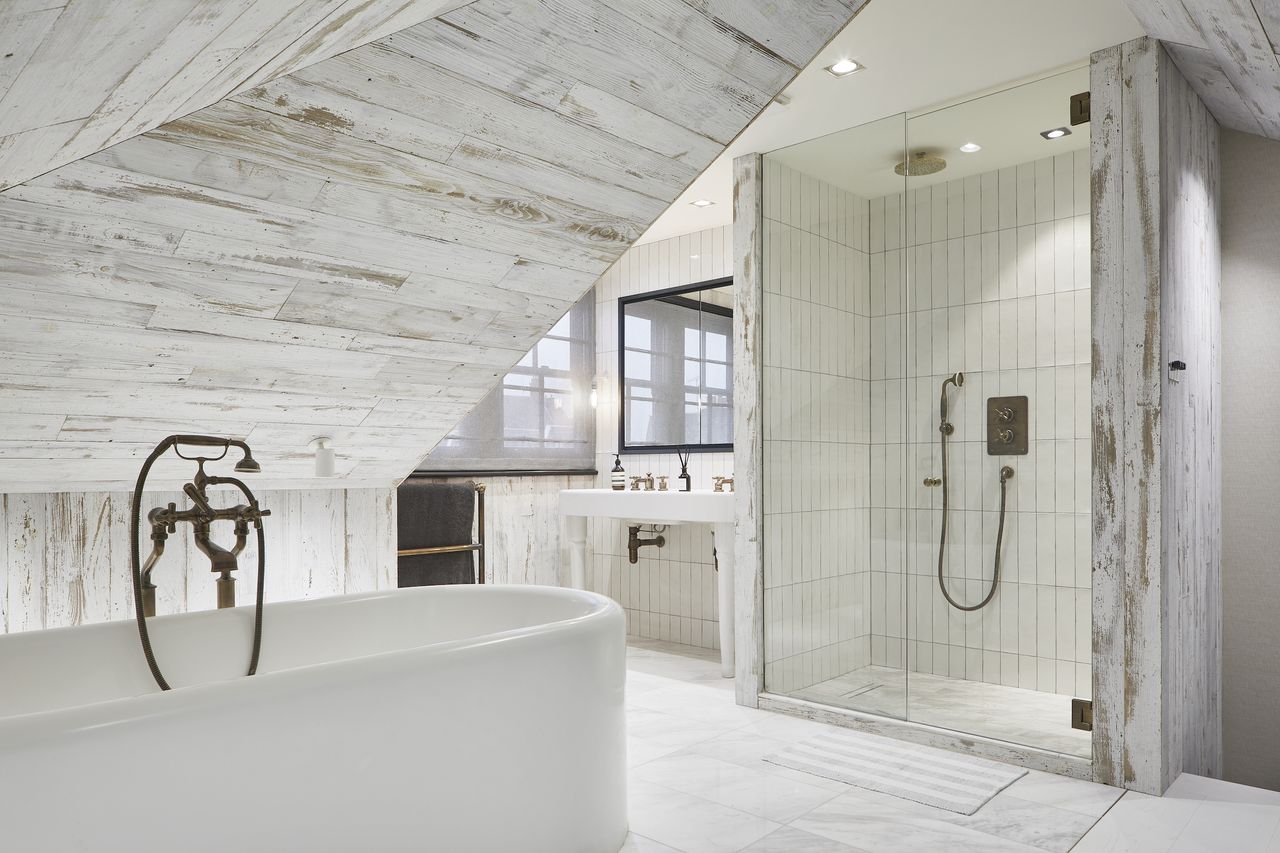 White bathroom with wood paneling, white bathtub, shower and vanity unit