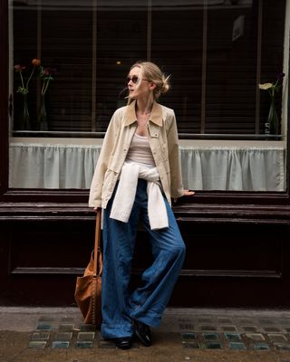 woman wearing barn jacket, jeans, and loafers spring outfit