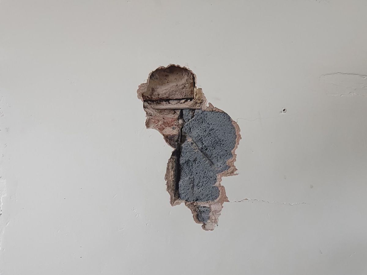 A DIY hole in a wall that looks like an old man in a hat