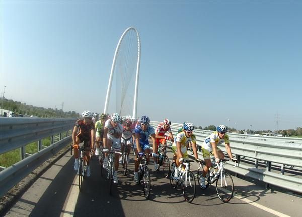 The peloton ride in an orderly fashion across the Reggio Emilia bridge.