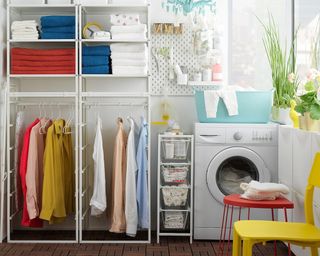 A laundry room with towels and clothes on a white ikea jonaxel open storage system
