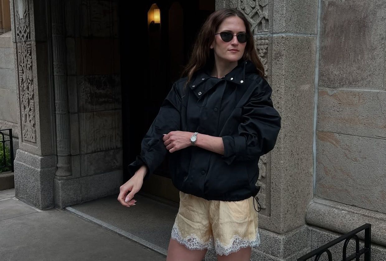 Eliza Huber wearing a sporty jacket, lace-trim shorts, and heeled sandals.