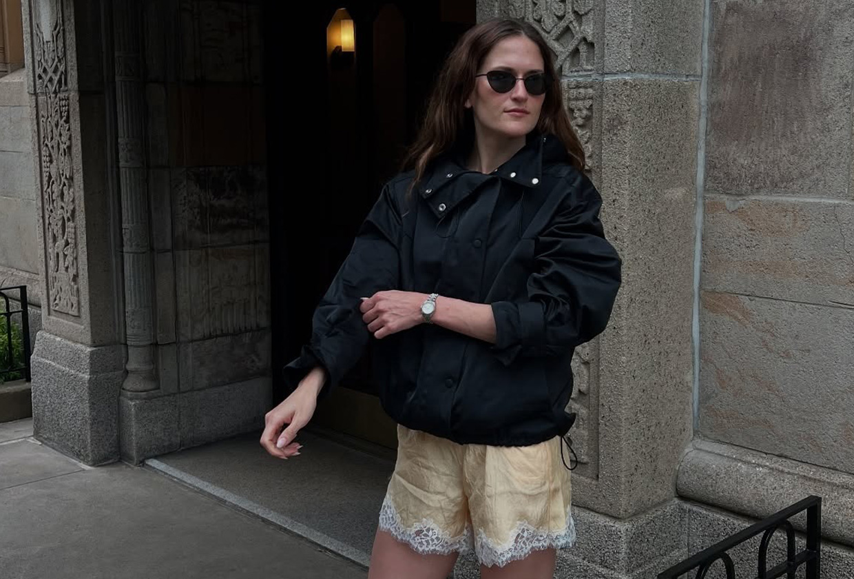 Eliza Huber wearing a sporty jacket, lace-trim shorts, and heeled sandals.