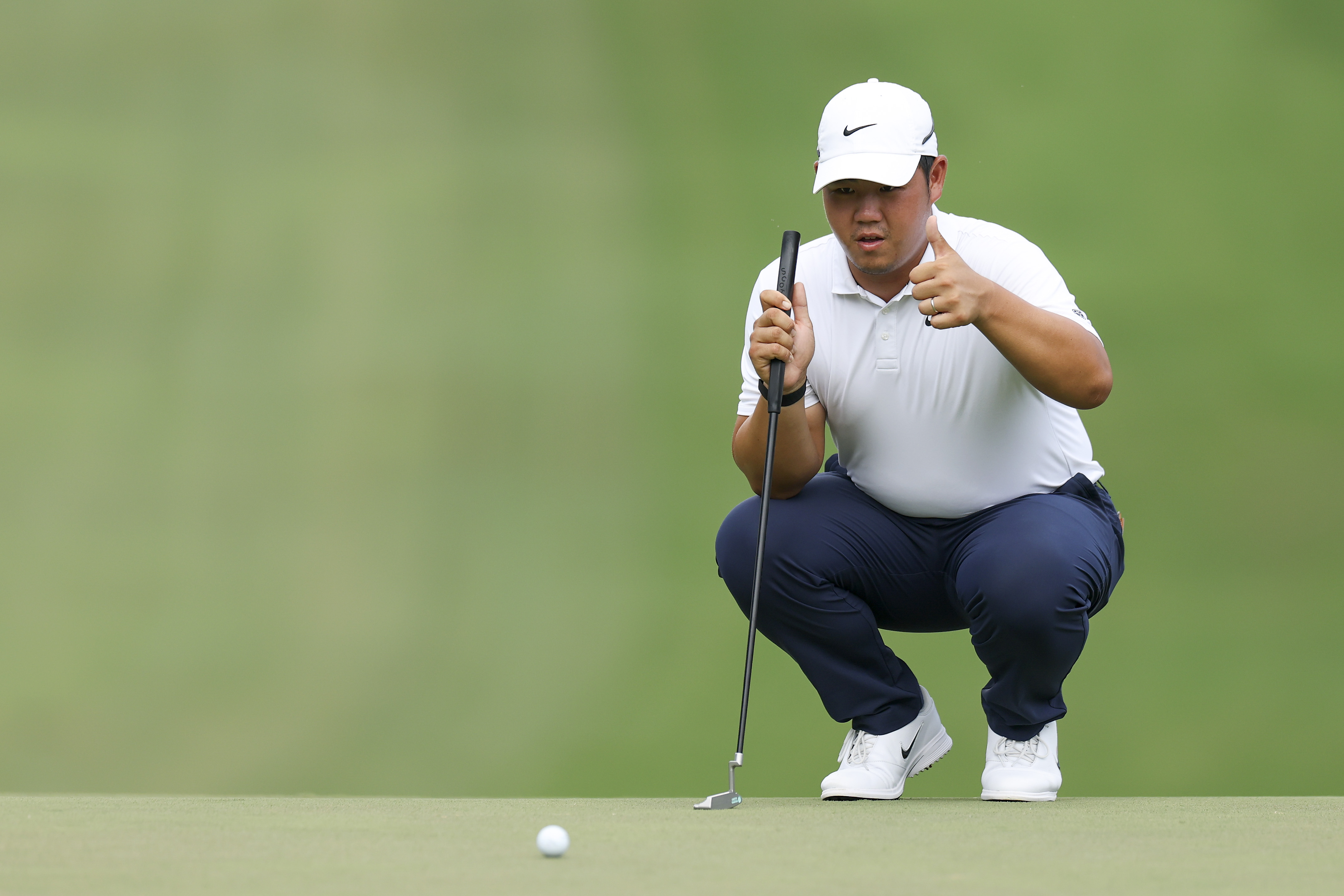 Tom Kim of South Korea lines up a putt on the 18th green during the third round of the Wyndham Championship 2026 at Sedgefield Country Club (Photo by Caleb Bowlin/Getty Images)