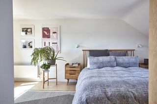 Bedroom in a loft with natural wood furniture including Ercol bed