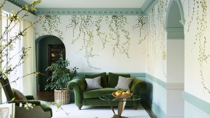  living room with green velvet sofa and chair, trailing ivy wallpaper and aqua woodwork 