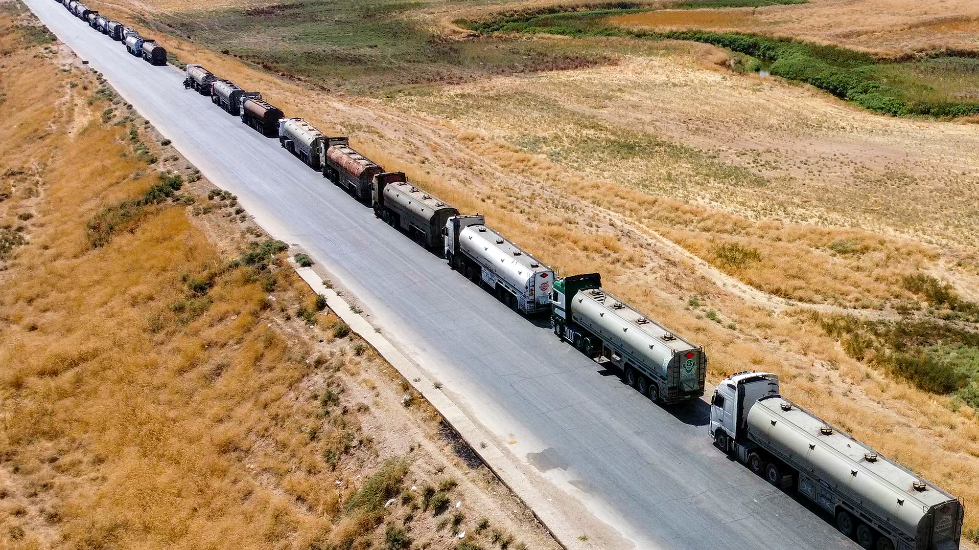 Oil tanker trucks line the M4 highway in northeastern Syria after residents blocked the refinery routes to protest recent fuel price hikes