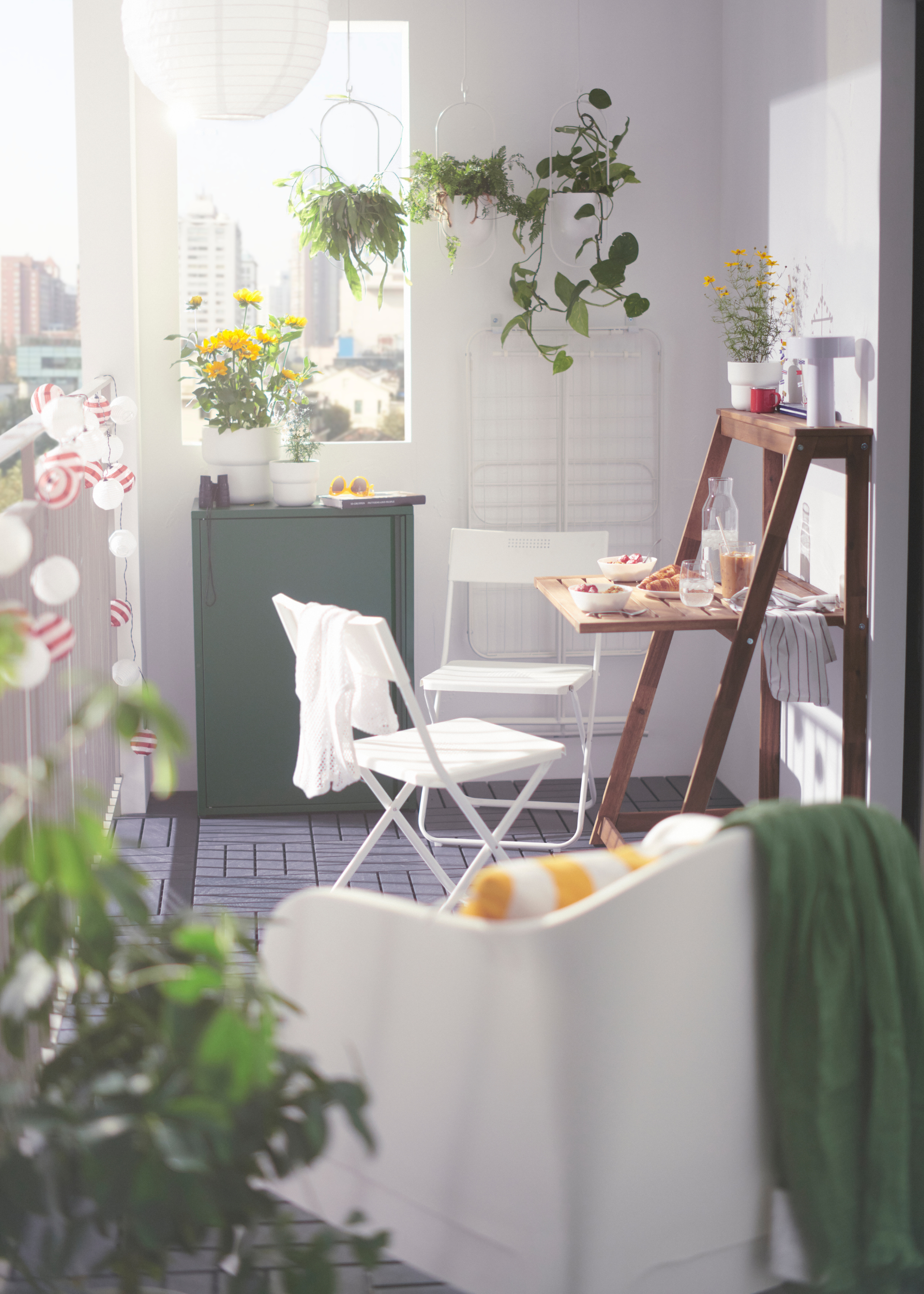IKEA DJUPON Outdoor Folding Table unfolded on a balcony with two chairs surrounded by plants