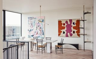 Dining area featuring marble dining table, slanted light fixture, and colourful artwork on the wall
