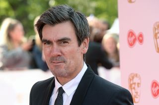 Jeff Hordley on the red carpet wearing a black suit and white shirt