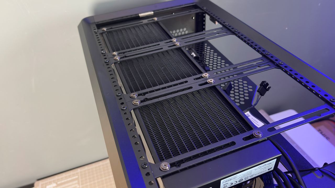 The CoolerMaster MasterFrame 360 Panoramic PC case with various components installed on a desk.