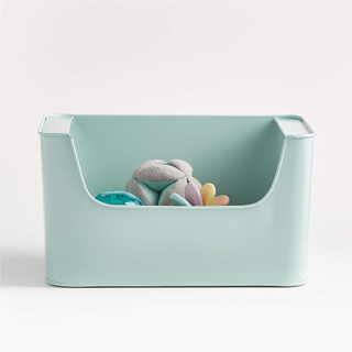 A mint green metal storage bin with kid's toys