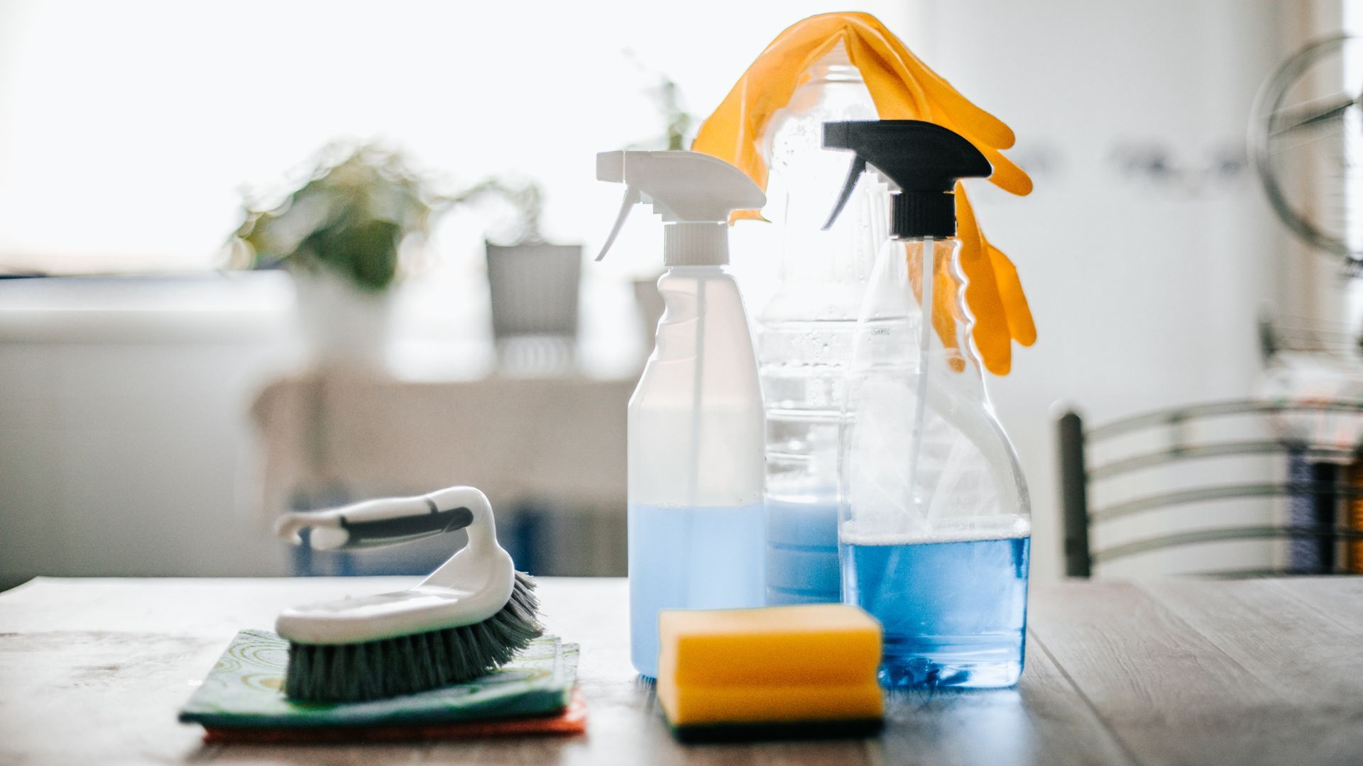 assortment of cleaning products and tools on wooden table