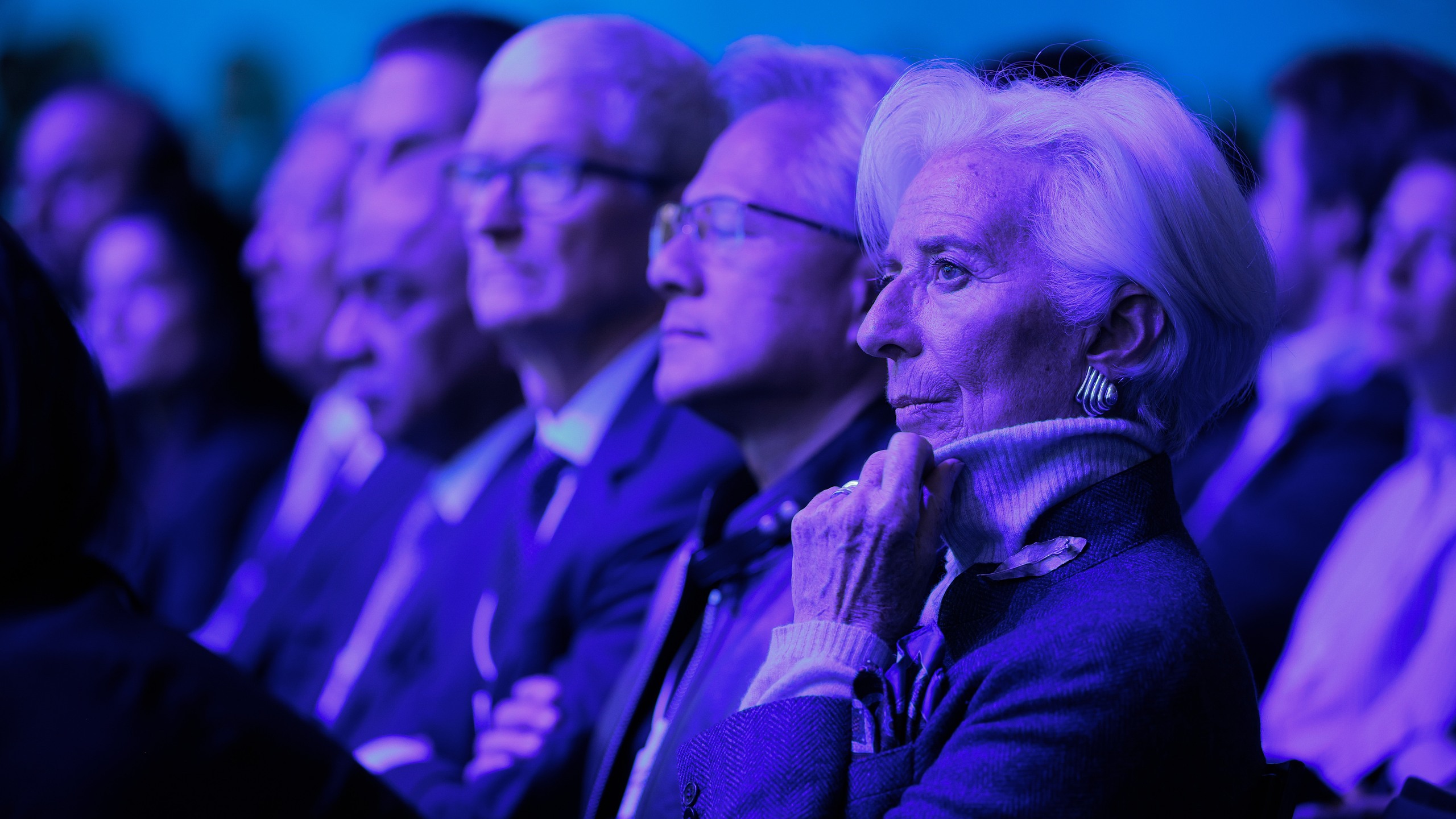Tim Cook, Jensen Huang, and Christine Lagarde listening to a speech by Donald Trump at the WEF.